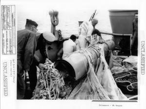 Navy personnel examine weapon #4, still tangled in its parachutes. 