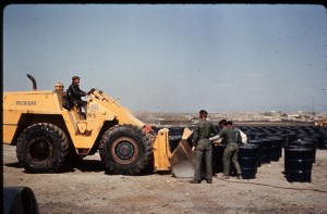 Air Force men loaded contaminated dirt and vegetation into 4,810 barrels for shipment back to the United States. The barrels were staged on the beach awaiting pickup from the Navy. 
